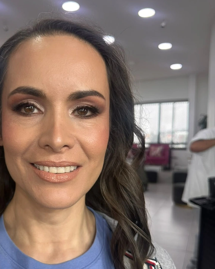 Clienta de unos cuarenta que sonríe con ahumado en bronce y labios nude.